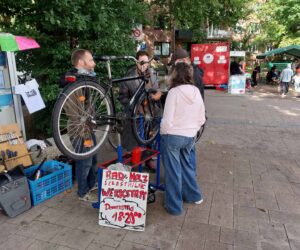 Die mobile Fahrradwerkstatt steht auf dem Stadtteilfest und repariert ein Fahrrad