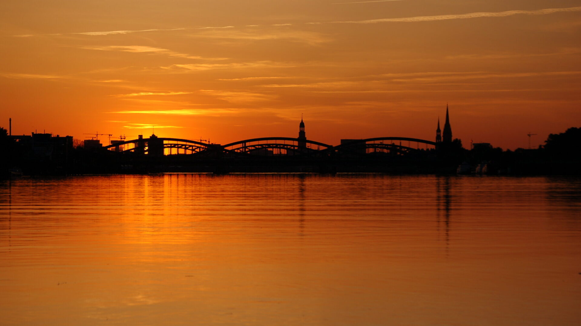 Sonnenuntergang hinter den Elbbrücken und Hamburger Hauptkirchen